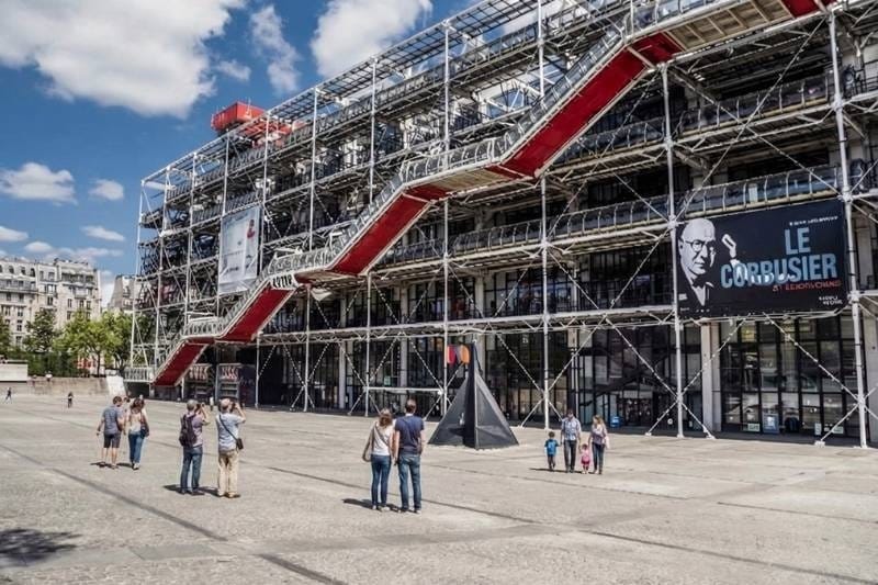 Exterior of the Centre Pompidou with red escalators and visitors in the plaza