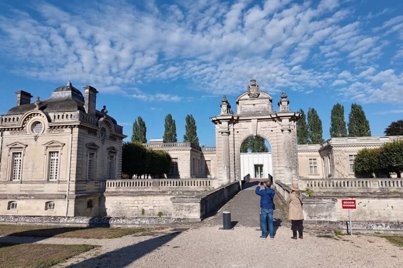 Grand entrance gate of the Château de Blérancourt under a dramatic sky