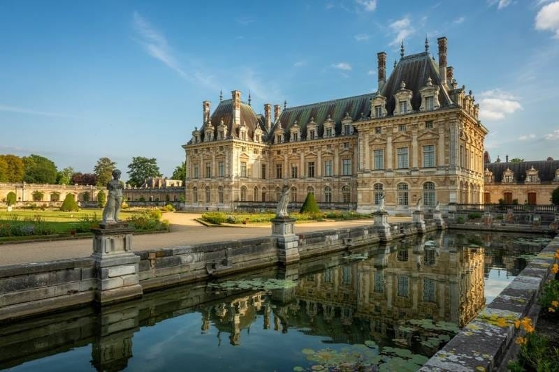Château de Fontainebleau reflected in the ornamental pond at golden hour