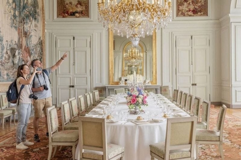 Ornate dining room at Château de Rambouillet with chandelier and set table