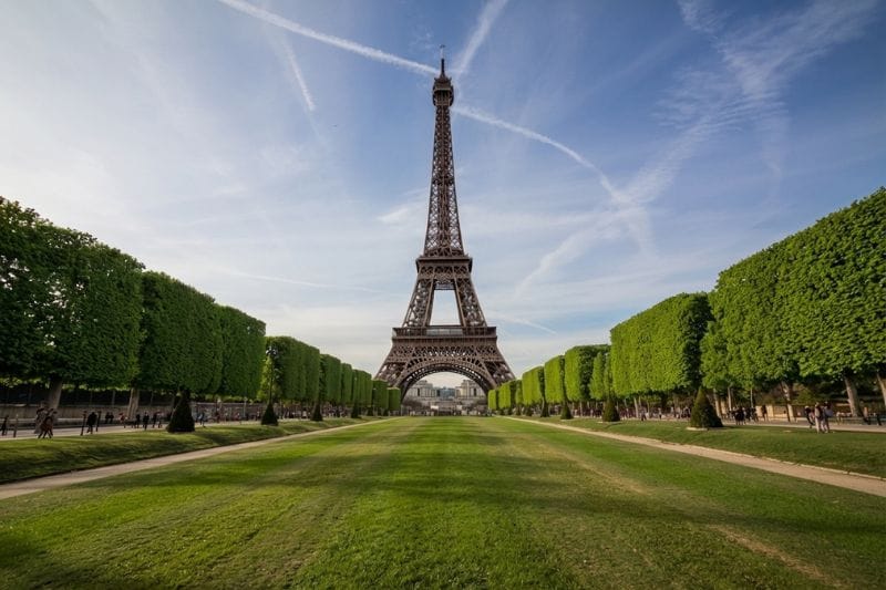 Eiffel Tower viewed from tree-lined Champ de Mars gardens Paris